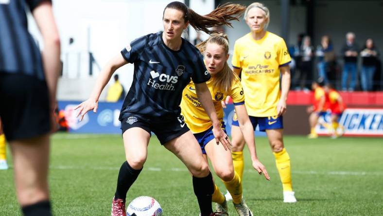 Mar 31, 2024; Washington, District of Columbia, USA; Washington Spirit midfielder Andi Sullivan (12) dribbles the ball against Utah Royals FC midfielder Dana Foederer (22) during the first half of the match at Audi Field. Mandatory Credit: Amber Searls-USA TODAY Sports