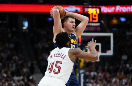 Mar 31, 2024; Denver, Colorado, USA; Denver Nuggets center Nikola Jokic (15) prepares to pass the ball over Cleveland Cavaliers guard Donovan Mitchell (45) in the first quarter at Ball Arena. Mandatory Credit: Ron Chenoy-USA TODAY Sports