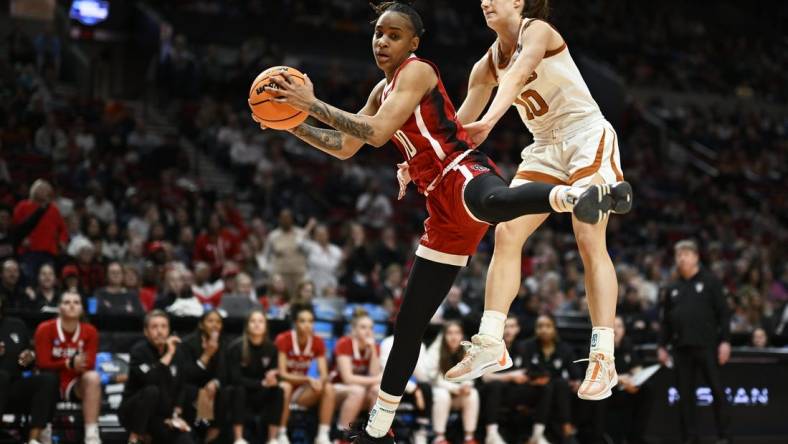 Mar 31, 2024; Portland, OR, USA; NC State Wolfpack guard Aziaha James (10) grabs a rebound during the first half against Texas Longhorns guard Shay Holle (10) in the finals of the Portland Regional of the NCAA Tournament at the Moda Center center. Mandatory Credit: Troy Wayrynen-USA TODAY Sports