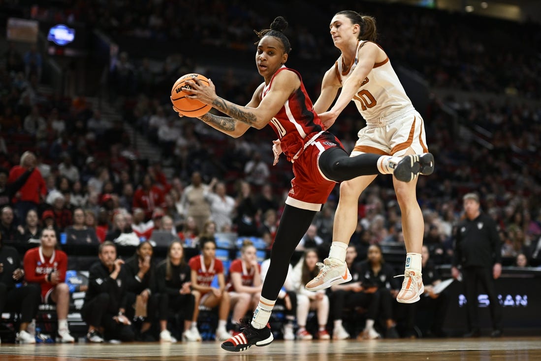 Mar 31, 2024; Portland, OR, USA; NC State Wolfpack guard Aziaha James (10) grabs a rebound during the first half against Texas Longhorns guard Shay Holle (10) in the finals of the Portland Regional of the NCAA Tournament at the Moda Center center. Mandatory Credit: Troy Wayrynen-USA TODAY Sports