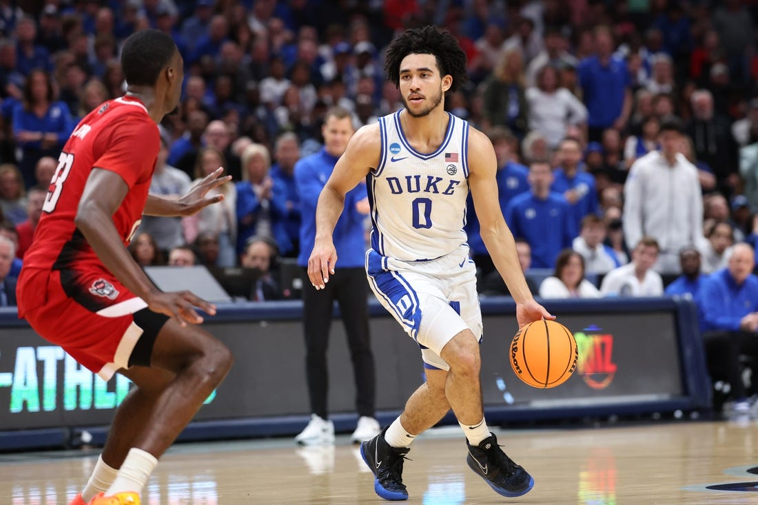 Mar 31, 2024; Dallas, TX, USA; Duke Blue Devils guard Jared McCain (0) controls the ball against North Carolina State Wolfpack forward Mohamed Diarra (23) in the first half in the finals of the South Regional of the 2024 NCAA Tournament at American Airline Center. Mandatory Credit: Kevin Jairaj-USA TODAY Sports