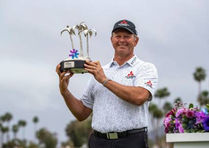 Retief Goosen holds up the Galleri Classic trophy after the final round at Mission Hills Country Club in Rancho Mirage, Calif., Sunday, March 31, 2024.