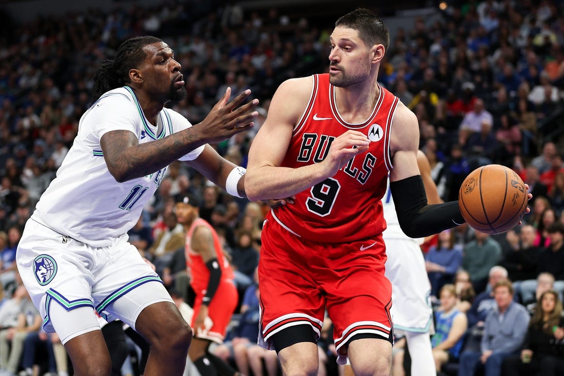 Mar 31, 2024; Minneapolis, Minnesota, USA; Chicago Bulls center Nikola Vucevic (9) passes as Minnesota Timberwolves center Naz Reid (11) defends during the first half at Target Center. Mandatory Credit: Matt Krohn-USA TODAY Sports