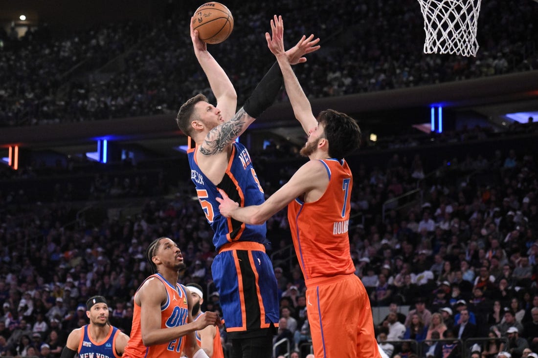 Mar 31, 2024; New York, New York, USA; New York Knicks center Isaiah Hartenstein (55) shoots the ball while being defended by Oklahoma City Thunder forward Chet Holmgren (7) and Oklahoma City Thunder guard Aaron Wiggins (21) during the second quarter at Madison Square Garden. Mandatory Credit: John Jones-USA TODAY Sports