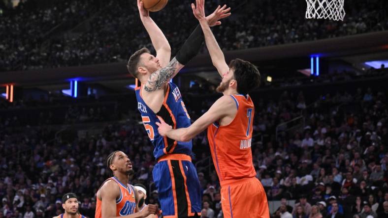 Mar 31, 2024; New York, New York, USA; New York Knicks center Isaiah Hartenstein (55) shoots the ball while being defended by Oklahoma City Thunder forward Chet Holmgren (7) and Oklahoma City Thunder guard Aaron Wiggins (21) during the second quarter at Madison Square Garden. Mandatory Credit: John Jones-USA TODAY Sports