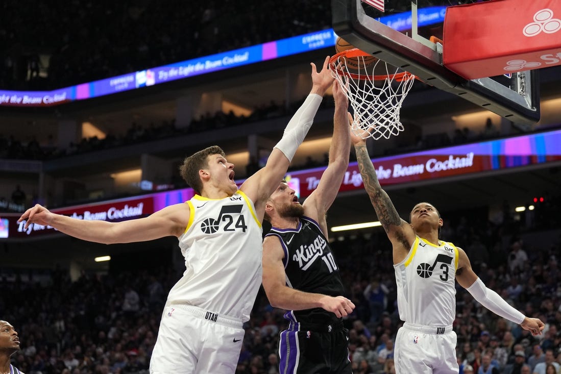 Mar 31, 2024; Sacramento, California, USA; Sacramento Kings forward Domantas Sabonis (10) shoots against Utah Jazz center Walker Kessler (24) and guard Keyonte George (3) during the second quarter at Golden 1 Center. Mandatory Credit: Darren Yamashita-USA TODAY Sports