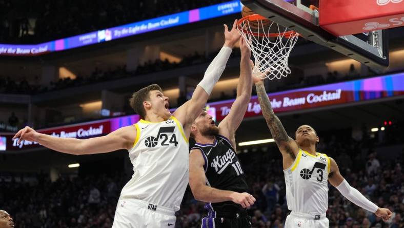 Mar 31, 2024; Sacramento, California, USA; Sacramento Kings forward Domantas Sabonis (10) shoots against Utah Jazz center Walker Kessler (24) and guard Keyonte George (3) during the second quarter at Golden 1 Center. Mandatory Credit: Darren Yamashita-USA TODAY Sports