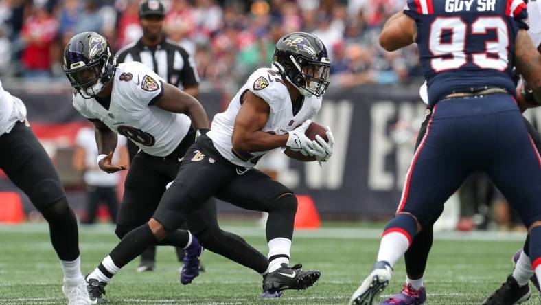 Sep 25, 2022; Foxborough, Massachusetts, USA; Baltimore Ravens running back JK Dobbins (27) runs the ball during the first half against the New England Patriots at Gillette Stadium. Mandatory Credit: Paul Rutherford-USA TODAY Sports