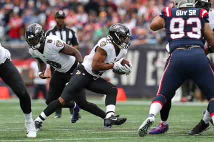 Sep 25, 2022; Foxborough, Massachusetts, USA; Baltimore Ravens running back JK Dobbins (27) runs the ball during the first half against the New England Patriots at Gillette Stadium. Mandatory Credit: Paul Rutherford-USA TODAY Sports