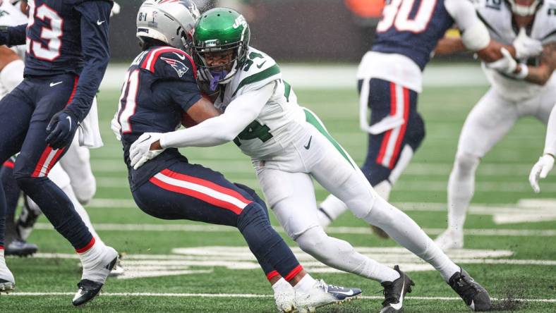 Sep 24, 2023; East Rutherford, New Jersey, USA; New England Patriots wide receiver Demario Douglas (81) is tackled by New York Jets cornerback Justin Hardee (34) during the first half at MetLife Stadium. Mandatory Credit: Vincent Carchietta-USA TODAY Sports