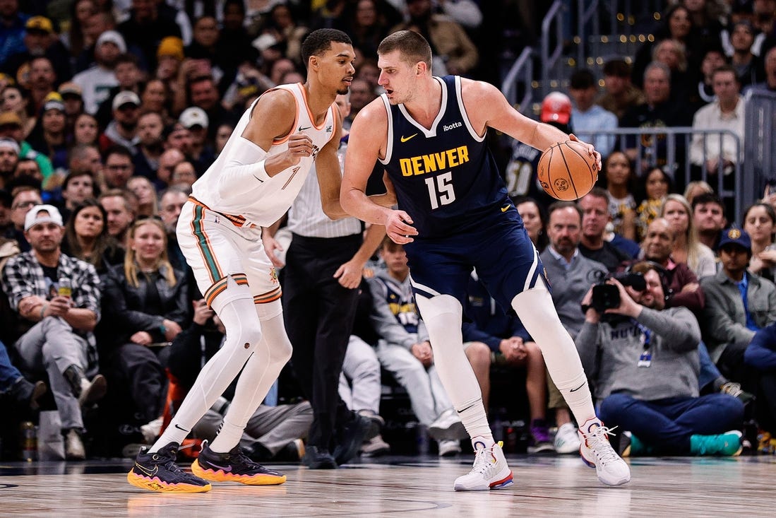 Nov 26, 2023; Denver, Colorado, USA; Denver Nuggets center Nikola Jokic (15) controls the ball as San Antonio Spurs center Victor Wembanyama (1) guards in the third quarter at Ball Arena. Mandatory Credit: Isaiah J. Downing-USA TODAY Sports