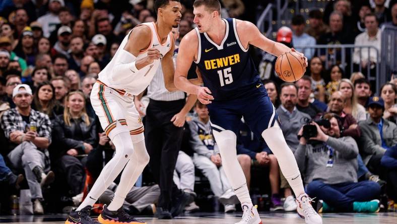 Nov 26, 2023; Denver, Colorado, USA; Denver Nuggets center Nikola Jokic (15) controls the ball as San Antonio Spurs center Victor Wembanyama (1) guards in the third quarter at Ball Arena. Mandatory Credit: Isaiah J. Downing-USA TODAY Sports