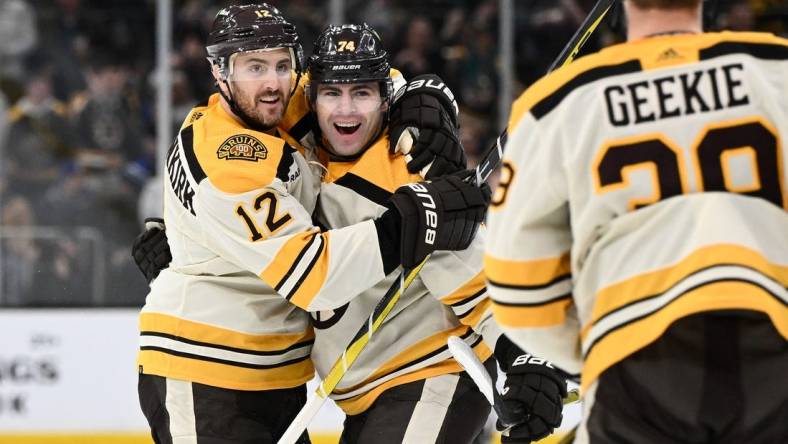 Mar 21, 2024; Boston, Massachusetts, USA; Boston Bruins left wing Jake DeBrusk (74) celebrates with defenseman Kevin Shattenkirk (12) and center Morgan Geekie (39) after scoring a goal against the New York Rangers during the first period at the TD Garden. Mandatory Credit: Brian Fluharty-USA TODAY Sports