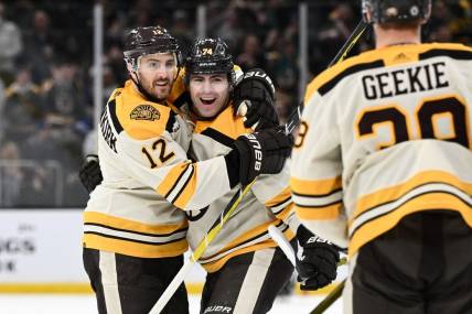 Mar 21, 2024; Boston, Massachusetts, USA; Boston Bruins left wing Jake DeBrusk (74) celebrates with defenseman Kevin Shattenkirk (12) and center Morgan Geekie (39) after scoring a goal against the New York Rangers during the first period at the TD Garden. Mandatory Credit: Brian Fluharty-USA TODAY Sports