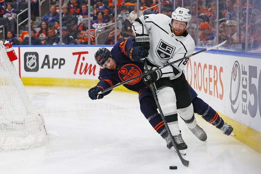 Mar 28, 2024; Edmonton, Alberta, CAN; Edmonton Oilers forward Warren Foegele (37) tries to knock Los Angeles Kings defensemen Vladislav Gavrikov (84) off the puck during the third period at Rogers Place. Mandatory Credit: Perry Nelson-USA TODAY Sports