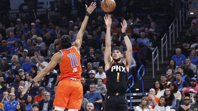 Mar 29, 2024; Oklahoma City, Oklahoma, USA; Phoenix Suns guard Devin Booker (1) shoots a three-point basket as Oklahoma City Thunder guard Isaiah Joe (11) defends during the first half at Paycom Center. Mandatory Credit: Alonzo Adams-USA TODAY Sports