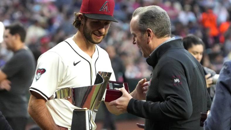 Mar 29, 2024; Phoenix, Arizona, USA; Arizona Diamondbacks President/CEO Derrick Hall presents pitcher Zac Gallen (23) a National League Championship Ring before a game against the Colorado Rockies at Chase Field. Mandatory Credit: Rick Scuteri-USA TODAY Sports