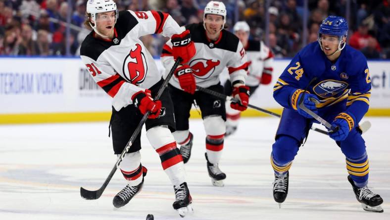 Mar 29, 2024; Buffalo, New York, USA;  Buffalo Sabres center Dylan Cozens (24) watches as New Jersey Devils center Dawson Mercer (91) makes a pass during the third period at KeyBank Center. Mandatory Credit: Timothy T. Ludwig-USA TODAY Sports