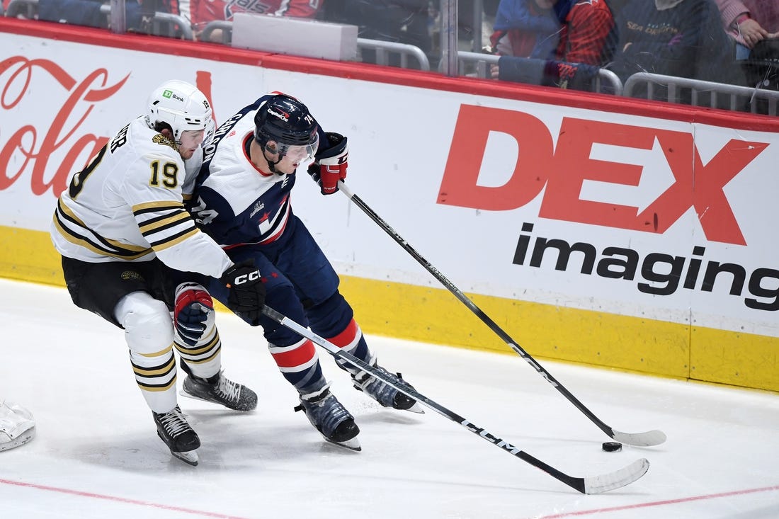 Mar 30, 2024; Washington, District of Columbia, USA; Washington Capitals defenseman John Carlson (74) controls the puck against Boston Bruins center John Beecher (19) during the third period at Capital One Arena. Mandatory Credit: Hannah Foslien-USA TODAY Sports