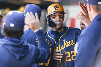 Mar 31, 2024; New York City, New York, USA;  Milwaukee Brewers left fielder Christian Yelich (22) is greeted in the dugout after scoring in the first inning against the New York Mets at Citi Field. Mandatory Credit: Wendell Cruz-USA TODAY Sports