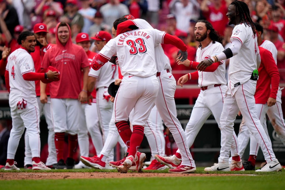 Cincinnati Reds center fielder Will Benson (30) embraces Cincinnati Reds first baseman Christian Encarnacion-Strand (33) after he hit a walk-off home run in the ninth inning of a baseball game against the Washington Nationals, Sunday, March 31, 2024, at Great American Ball Park in Cincinnati.