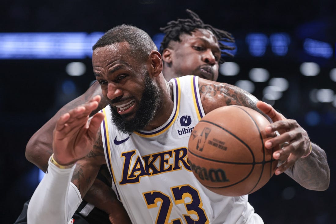 Mar 31, 2024; Brooklyn, New York, USA; Los Angeles Lakers forward LeBron James (23) drives to the basket against Brooklyn Nets forward Trendon Watford (9) during the second half at Barclays Center. Mandatory Credit: Vincent Carchietta-USA TODAY Sports