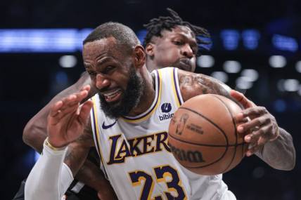 Mar 31, 2024; Brooklyn, New York, USA; Los Angeles Lakers forward LeBron James (23) drives to the basket against Brooklyn Nets forward Trendon Watford (9) during the second half at Barclays Center. Mandatory Credit: Vincent Carchietta-USA TODAY Sports