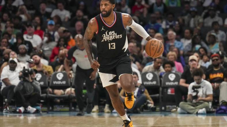 Mar 31, 2024; Charlotte, North Carolina, USA; LA Clippers forward Paul George (13) brings the ball up court against the Charlotte Hornets during the second half at Spectrum Center. Mandatory Credit: Jim Dedmon-USA TODAY Sports