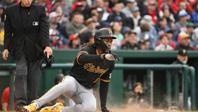 Apr 1, 2024; Washington, District of Columbia, USA; Pittsburgh Pirates shortstop Oneil Cruz (15) slides into home to score a run against the Washington Nationals at Nationals Park. Mandatory Credit: Rafael Suanes-USA TODAY Sports