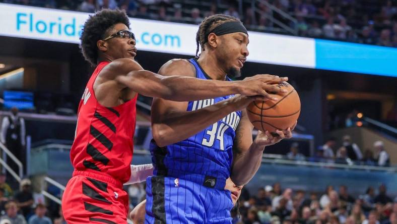 Apr 1, 2024; Orlando, Florida, USA; Orlando Magic center Wendell Carter Jr. (34) grabs the rebound from Portland Trail Blazers guard Scoot Henderson (00) during the first quarter at Amway Center. Mandatory Credit: Mike Watters-USA TODAY Sports