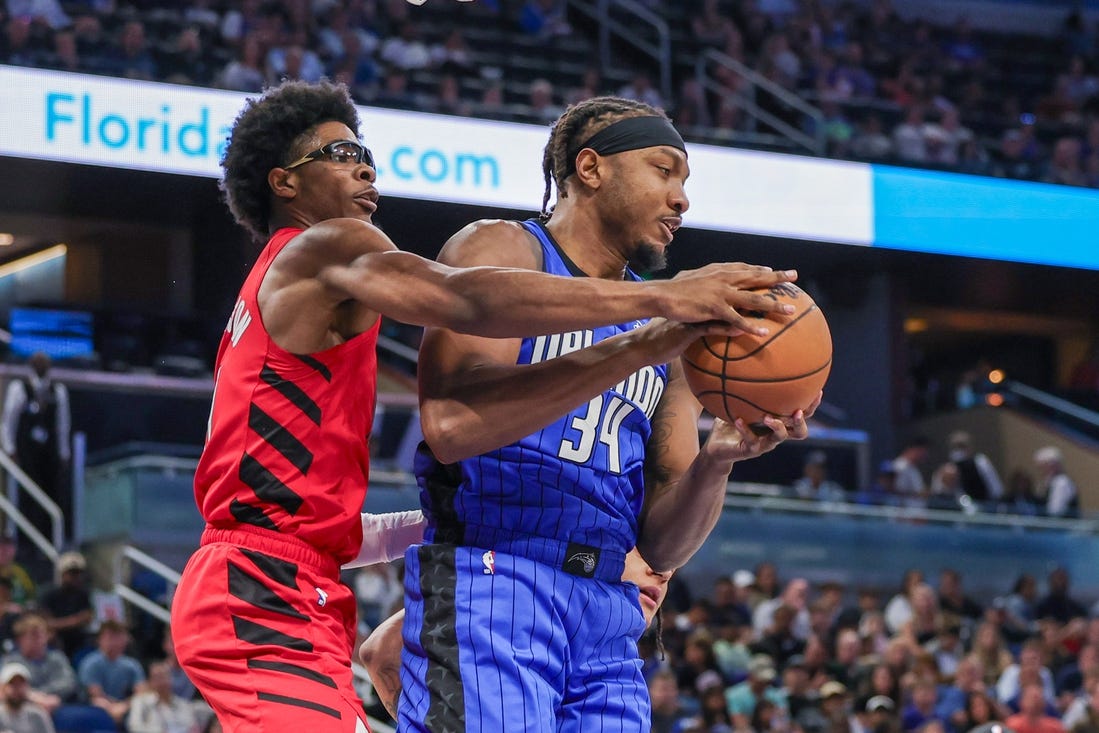 Apr 1, 2024; Orlando, Florida, USA; Orlando Magic center Wendell Carter Jr. (34) grabs the rebound from Portland Trail Blazers guard Scoot Henderson (00) during the first quarter at Amway Center. Mandatory Credit: Mike Watters-USA TODAY Sports