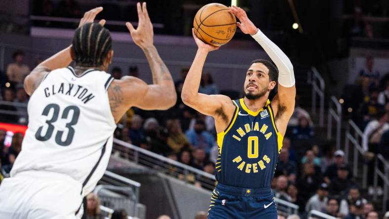 Apr 1, 2024; Indianapolis, Indiana, USA; Indiana Pacers guard Tyrese Haliburton (0) shoots the ball while Brooklyn Nets center Nic Claxton (33) defends in the first half at Gainbridge Fieldhouse. Mandatory Credit: Trevor Ruszkowski-USA TODAY Sports