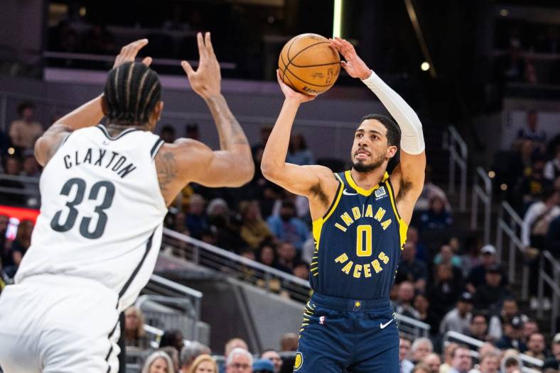 Apr 1, 2024; Indianapolis, Indiana, USA; Indiana Pacers guard Tyrese Haliburton (0) shoots the ball while Brooklyn Nets center Nic Claxton (33) defends in the first half at Gainbridge Fieldhouse. Mandatory Credit: Trevor Ruszkowski-USA TODAY Sports
