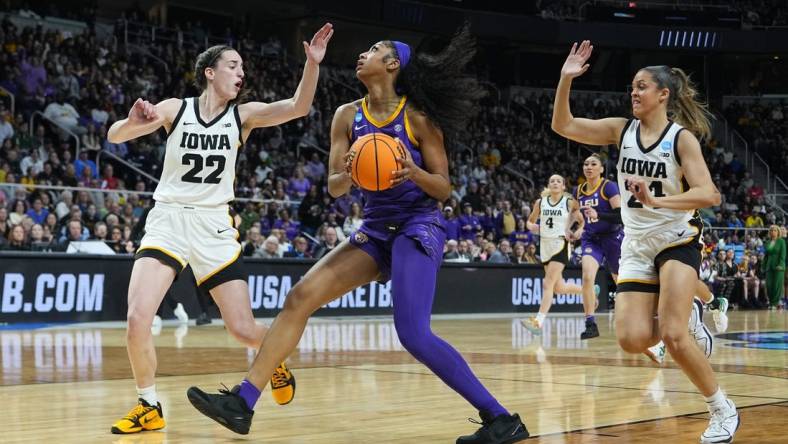 Apr 1, 2024; Albany, NY, USA; LSU Lady Tigers forward Angel Reese (10) controls the ball against Iowa Hawkeyes guard Caitlin Clark (22) and guard Gabbie Marshall (24) in the first half in the finals of the Albany Regional in the 2024 NCAA Tournament at MVP Arena. Mandatory Credit: Gregory Fisher-USA TODAY Sports