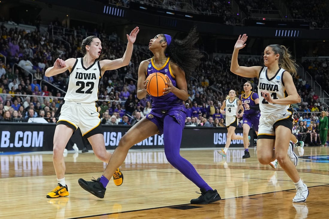 Apr 1, 2024; Albany, NY, USA; LSU Lady Tigers forward Angel Reese (10) controls the ball against Iowa Hawkeyes guard Caitlin Clark (22) and guard Gabbie Marshall (24) in the first half in the finals of the Albany Regional in the 2024 NCAA Tournament at MVP Arena. Mandatory Credit: Gregory Fisher-USA TODAY Sports