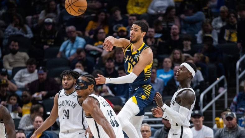 Apr 1, 2024; Indianapolis, Indiana, USA; Indiana Pacers guard Tyrese Haliburton (0) passes the ball while Brooklyn Nets center Nic Claxton (33) defends in the second half at Gainbridge Fieldhouse. Mandatory Credit: Trevor Ruszkowski-USA TODAY Sports