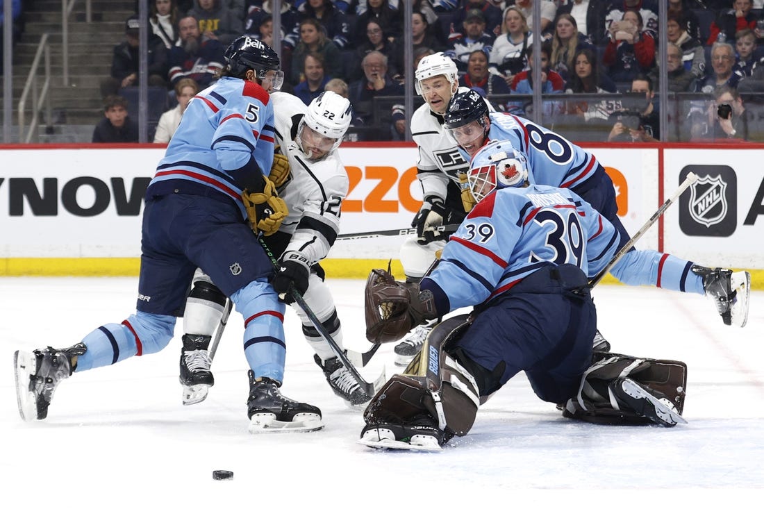 Apr 1, 2024; Winnipeg, Manitoba, CAN; Winnipeg Jets defenseman Brenden Dillon (5) and Los Angeles Kings left wing Kevin Fiala (22) scramble for the puck in front of Winnipeg Jets goaltender Laurent Brossoit (39) in the first period at Canada Life Centre. Mandatory Credit: James Carey Lauder-USA TODAY Sports