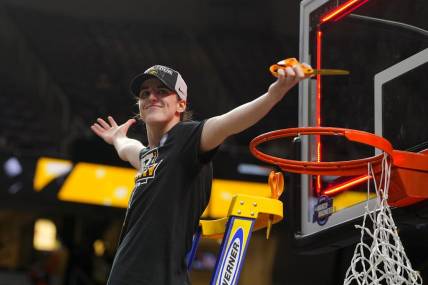 Apr 1, 2024; Albany, NY, USA; Iowa Hawkeyes guard Caitlin Clark (22) cuts the net after defeating the LSU Lady Tigers in the finals of the Albany Regional in the 2024 NCAA Tournament at MVP Arena. Mandatory Credit: Gregory Fisher-USA TODAY Sports