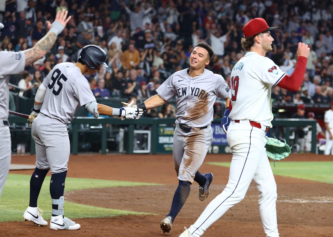 Apr 1, 2024; Phoenix, Arizona, USA; New York Yankees shortstop Anthony Volpe (center) celebrates with teammates after scoring against the Arizona Diamondbacks in the third inning at Chase Field. Mandatory Credit: Mark J. Rebilas-USA TODAY Sports