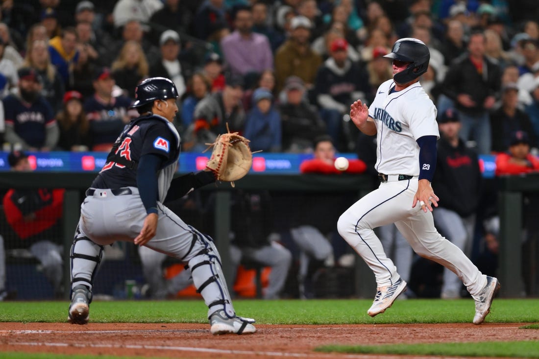 Apr 1, 2024; Seattle, Washington, USA; Cleveland Guardians catcher Bo Naylor (23) catches the ball and later tags out Seattle Mariners first baseman Ty France (23) at home plate during the fourth inning at T-Mobile Park. Mandatory Credit: Steven Bisig-USA TODAY Sports