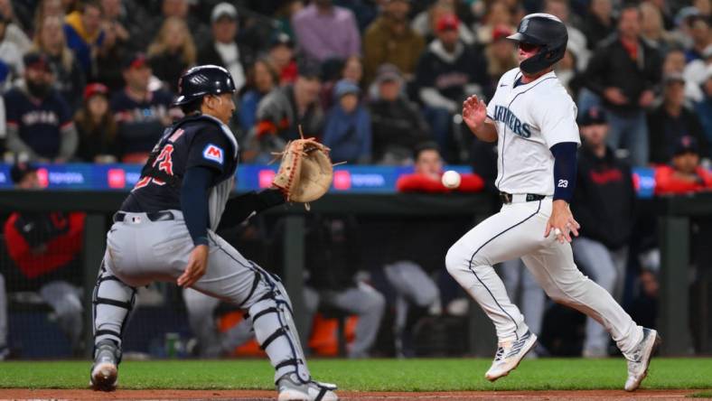 Apr 1, 2024; Seattle, Washington, USA; Cleveland Guardians catcher Bo Naylor (23) catches the ball and later tags out Seattle Mariners first baseman Ty France (23) at home plate during the fourth inning at T-Mobile Park. Mandatory Credit: Steven Bisig-USA TODAY Sports