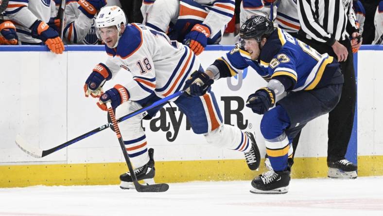 Apr 1, 2024; St. Louis, Missouri, USA; St. Louis Blues left wing Jake Neighbours (63) pressures Edmonton Oilers left wing Zach Hyman (18) during the third period at Enterprise Center. Mandatory Credit: Jeff Le-USA TODAY Sports
