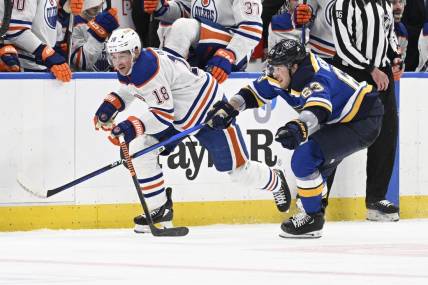 Apr 1, 2024; St. Louis, Missouri, USA; St. Louis Blues left wing Jake Neighbours (63) pressures Edmonton Oilers left wing Zach Hyman (18) during the third period at Enterprise Center. Mandatory Credit: Jeff Le-USA TODAY Sports