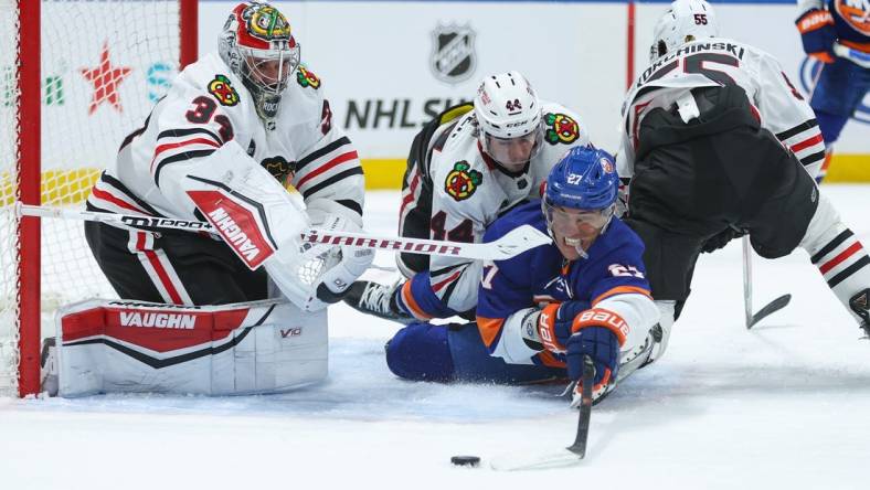 Apr 2, 2024; Elmont, New York, USA; New York Islanders left wing Anders Lee (27) attempts to take a shot on Chicago Blackhawks goaltender Petr Mrazek (34) during the second period at UBS Arena. Mandatory Credit: Thomas Salus-USA TODAY Sports
