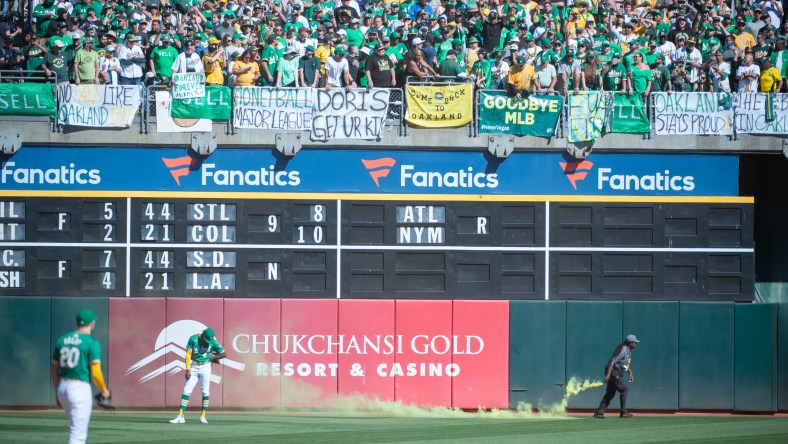 Oakland Athletics fans run onto field, throw smoke bombs in last game at Coliseum